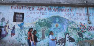 Residents of the Nahua town Cuentepec in Morelos walk by a multi-lingual mural.