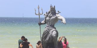 Visitors take photos near a statue of Poseidon in the ocean outside Progreso, Yucatán