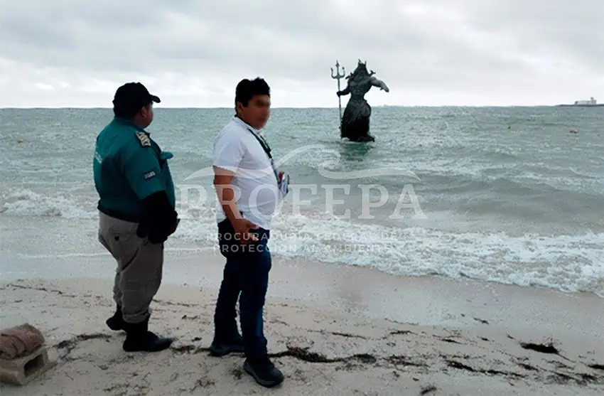 Profepa officials stand on the beach near the "closed" statue of Poseidon in Progreso, Yucatán.