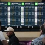 Airport screens showing dozens of canceled and delayed flights.