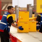 DHL worker in Mexico moving boxes on an conveyor belt in a warehouse