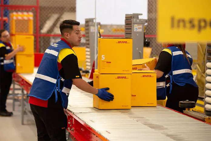 DHL worker in Mexico moving boxes on an conveyor belt in a warehouse