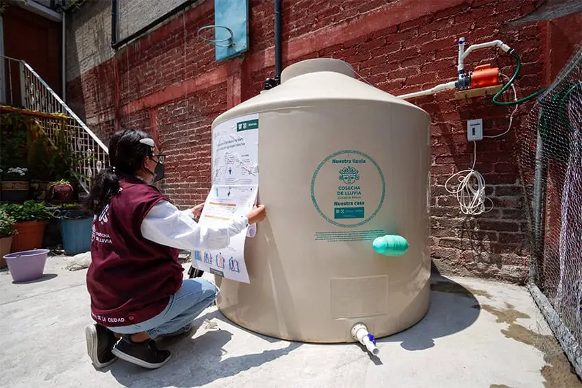 A Mexico City worker finishes installing a rainwater harvesting system, part of a program that Sheinbaum plans to expand.