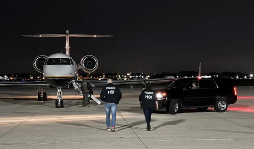 Landed, open small private plane in background with U.S. Department of Homeland Security agents approaching it