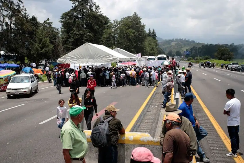 A group of people protesting along the Mexico-Puebla highway