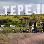 Giant Hollywood-like landmark sign bearing the name Tepeji stands in the hills.