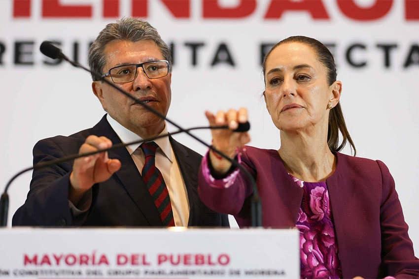 Claudia Sheinbaum at a podium with a grim expression