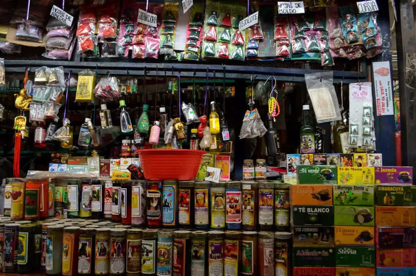 Santería market in Mexico with votive candles and sacred herbs.