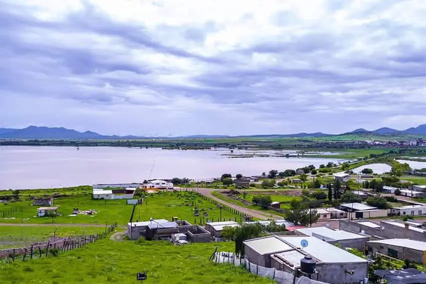 Laguna de Bustillos in June 2020, a thriving lake surrounded by homes on verdant grassy lands