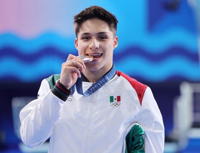 Diver Osmar Olvera bites his silver medal. What do Mexican Olympic medalists win when they come home?