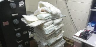Packages of a white powdery substance suspected to be illicit drugs sitting piled up in a CBP office