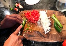 Hands chopping tomato, onion and jalapeño