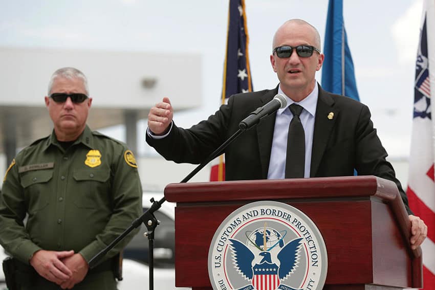 CBP Commissioner Troy Miller at a podium addressing a press conference about new drug trafficking enforcement initiatives at the US-Mexico border