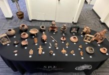 The 32 Mexican archaeological artifacts recently returned from Oregon, laid out on a black table.