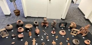 The 32 Mexican archaeological artifacts recently returned from Oregon, laid out on a black table.