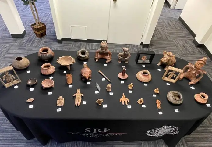 The 32 Mexican archaeological artifacts recently returned from Oregon, laid out on a black table.