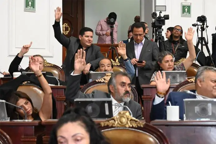 CDMX legislators raise their hands to vote on a rent control law