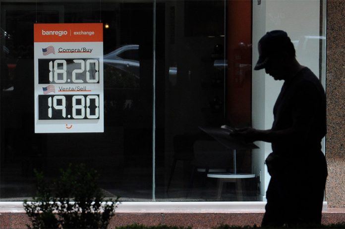 A Banregio currency exchange sign shows the dollar-peso exchange rate, as the Mexican peso strengthens.