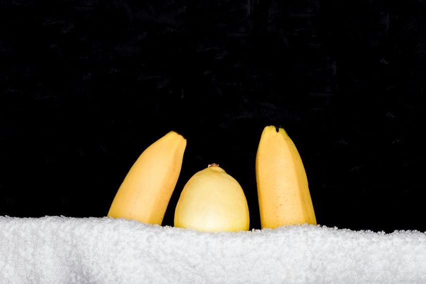 Lemon tucked under a cover between two bananas.