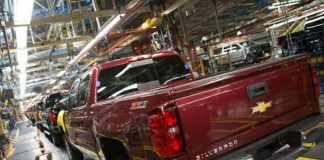 A red Chevy Silverado pickup truck in a productin line inside a factory