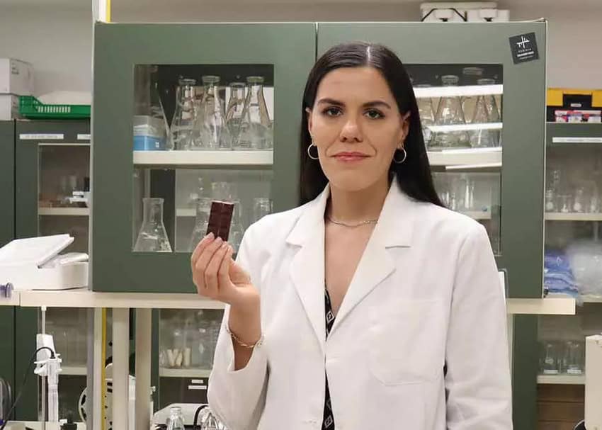 Dr. Paulina Faccinetto holds a piece of Lucid Mind chocolate in a laboratory