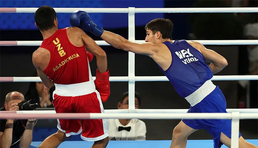 Mexican boxer Marco Verde tries to hit Asadkhuja Muydinkhujaev of Uzbekistan at the Paris 2024 Olympics.