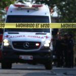 An ambulance rushes to the scene of a homicide.