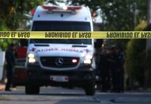 An ambulance rushes to the scene of a homicide.