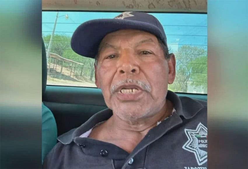 Antonio Riaño in police uniform, in the back of a police car.