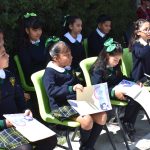 Mexican schoolchildren sitting on chairs outside