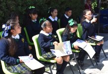 Mexican schoolchildren sitting on chairs outside