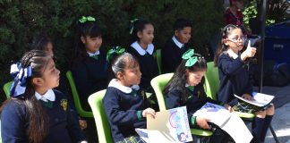 Mexican schoolchildren sitting on chairs outside