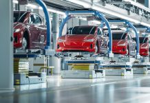 Red cars in the air on a robotic assembly line in Mexico