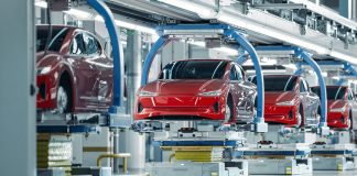 Red cars in the air on a robotic assembly line in Mexico