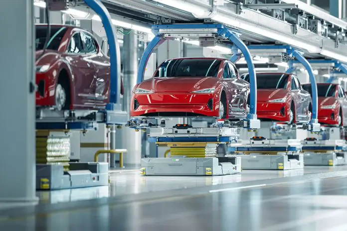 Red cars in the air on a robotic assembly line in Mexico