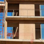 Red scaffolding and adobe stone frames of an apartment block being built in Los Cabos, Mexico.