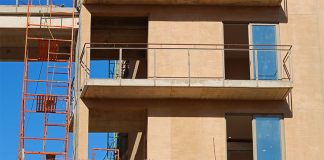 Red scaffolding and adobe stone frames of an apartment block being built in Los Cabos, Mexico.