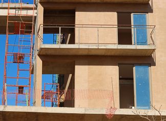 Red scaffolding and adobe stone frames of an apartment block being built in Los Cabos, Mexico.