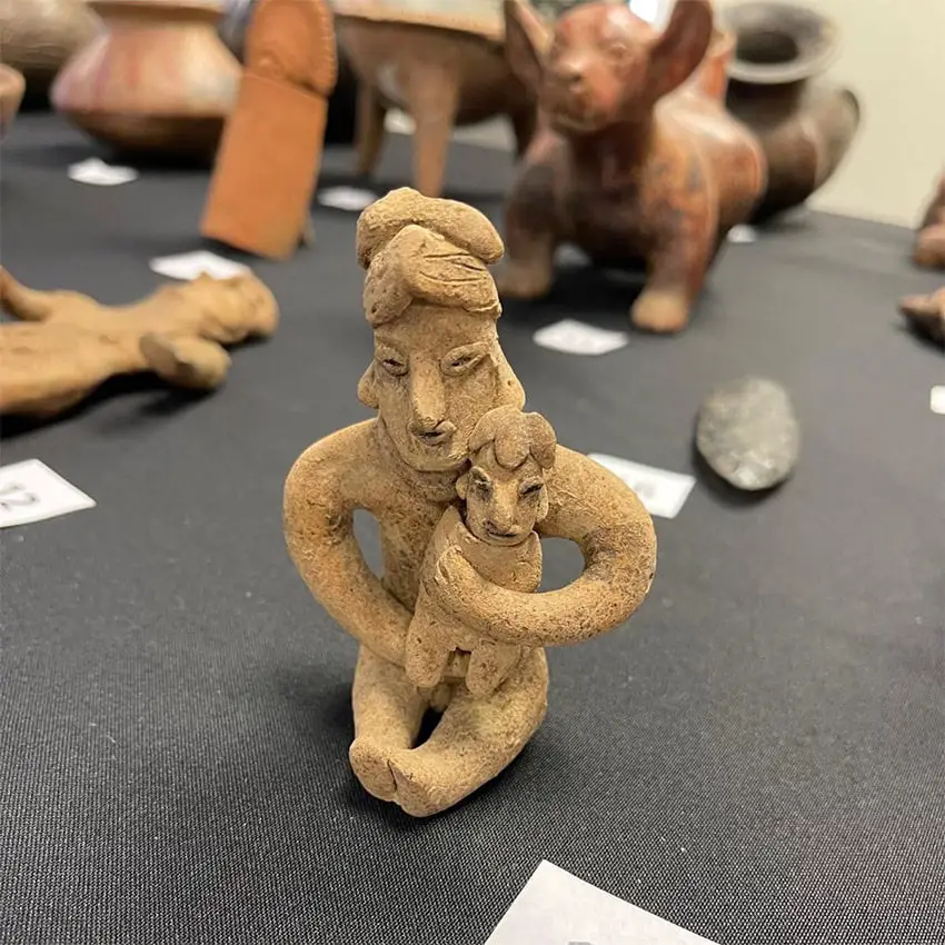 A clay figure of a woman holding a child, one of the archaeological artifacts returned to Mexico.