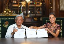 AMLO and Claudia Sheinbaum hold up the signed judicial reform bill