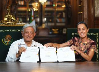 AMLO and Claudia Sheinbaum hold up the signed judicial reform bill