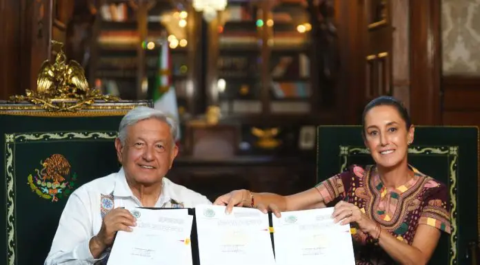 AMLO and Claudia Sheinbaum hold up the signed judicial reform bill