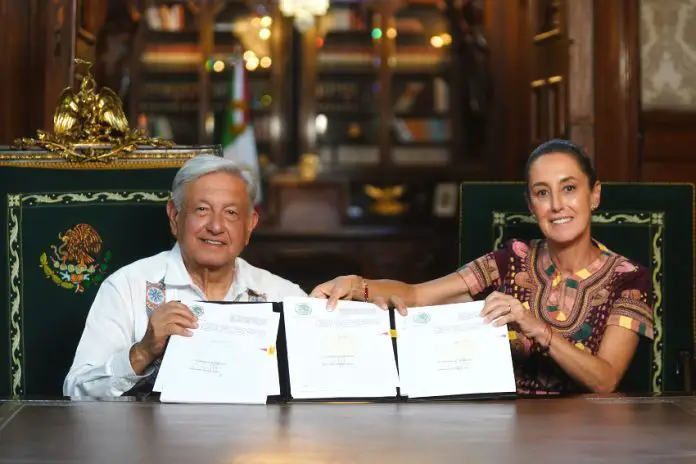 AMLO and Claudia Sheinbaum hold up the signed judicial reform bill