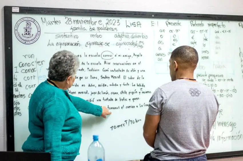 Profesora enseñando conjugación de verbos en español a un extranjero