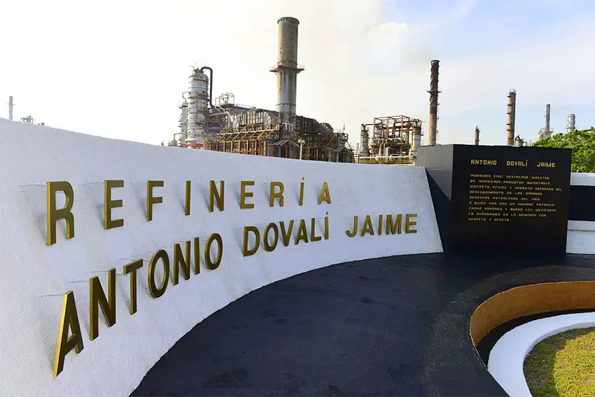 Entrance sign to Pemex's Salina Cruz refinery in Oaxaca, white with gold letters.