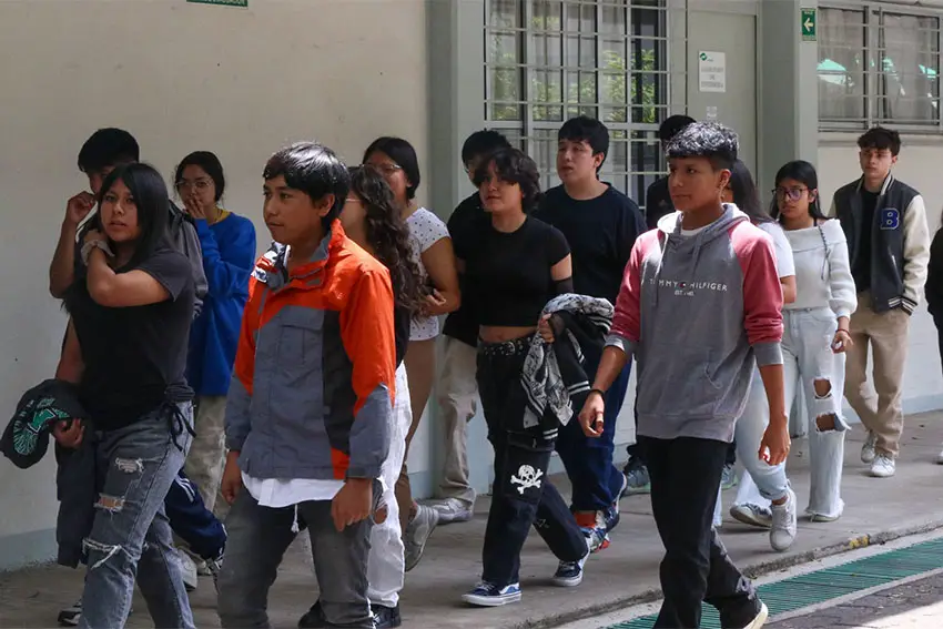 High school students walking in a group all in the same direction in a courtyard.