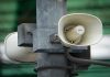 White megaphone-style loudspeakers mounted high on a metal pole in Mexico City, set up to alert citizens during earthquakes