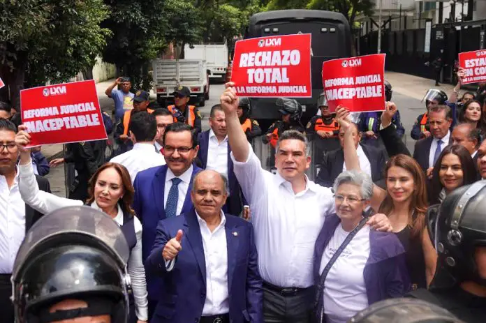 Mexican senators in suits hold signs reading 