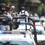 National Guard members perch atop security vehicles on patrol
