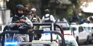 National Guard members perch atop security vehicles on patrol